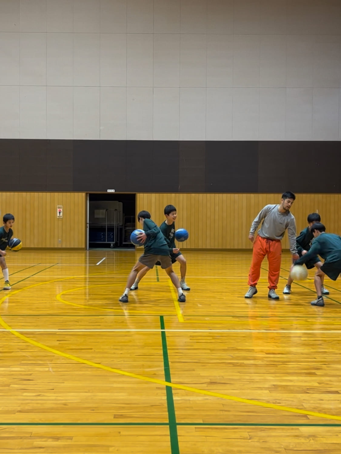 スクール生がペアになってバスケットボールの練習している様子の写真