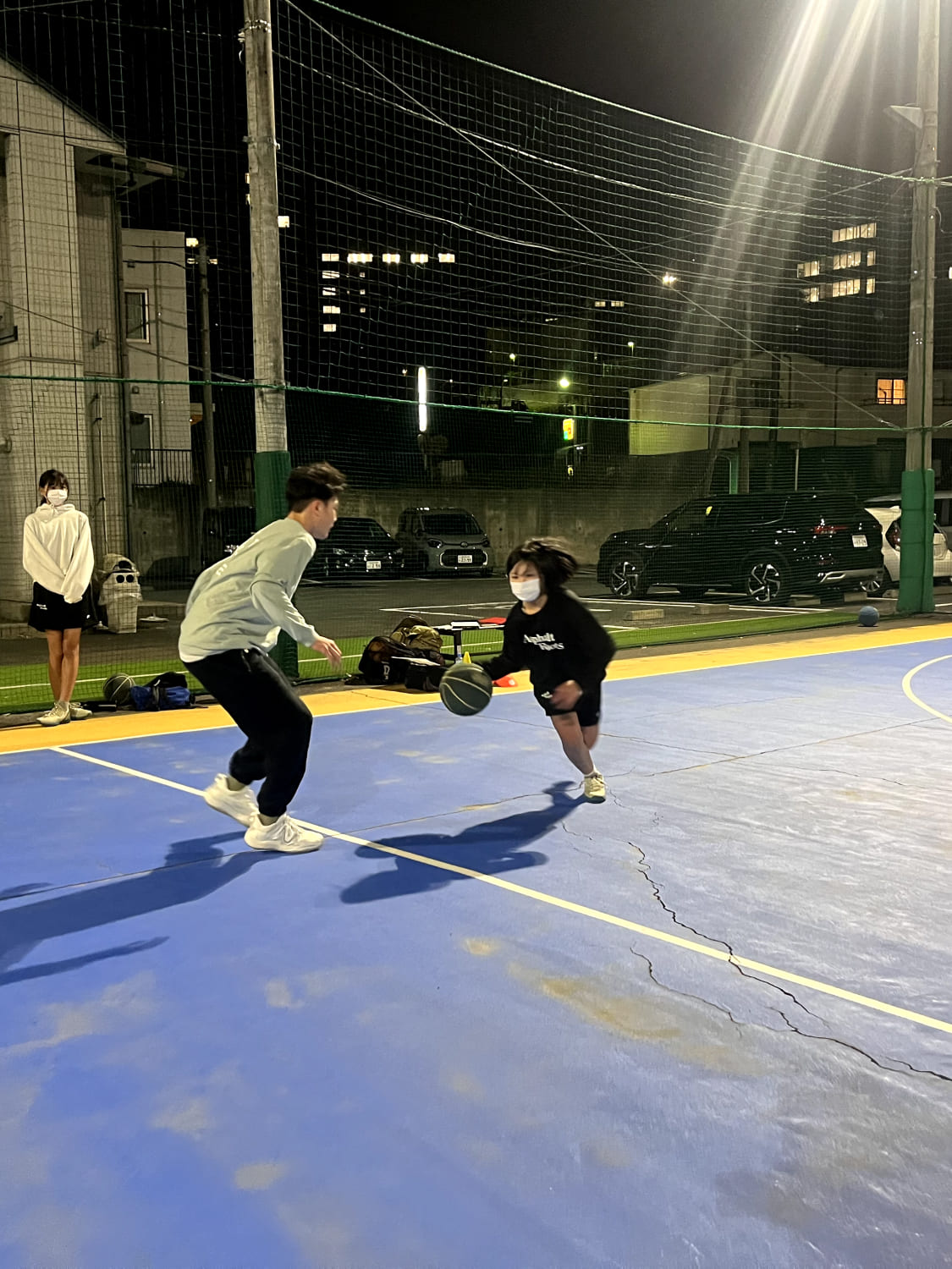 男性と女の子が1on1でバスケットボールをしている様子の写真